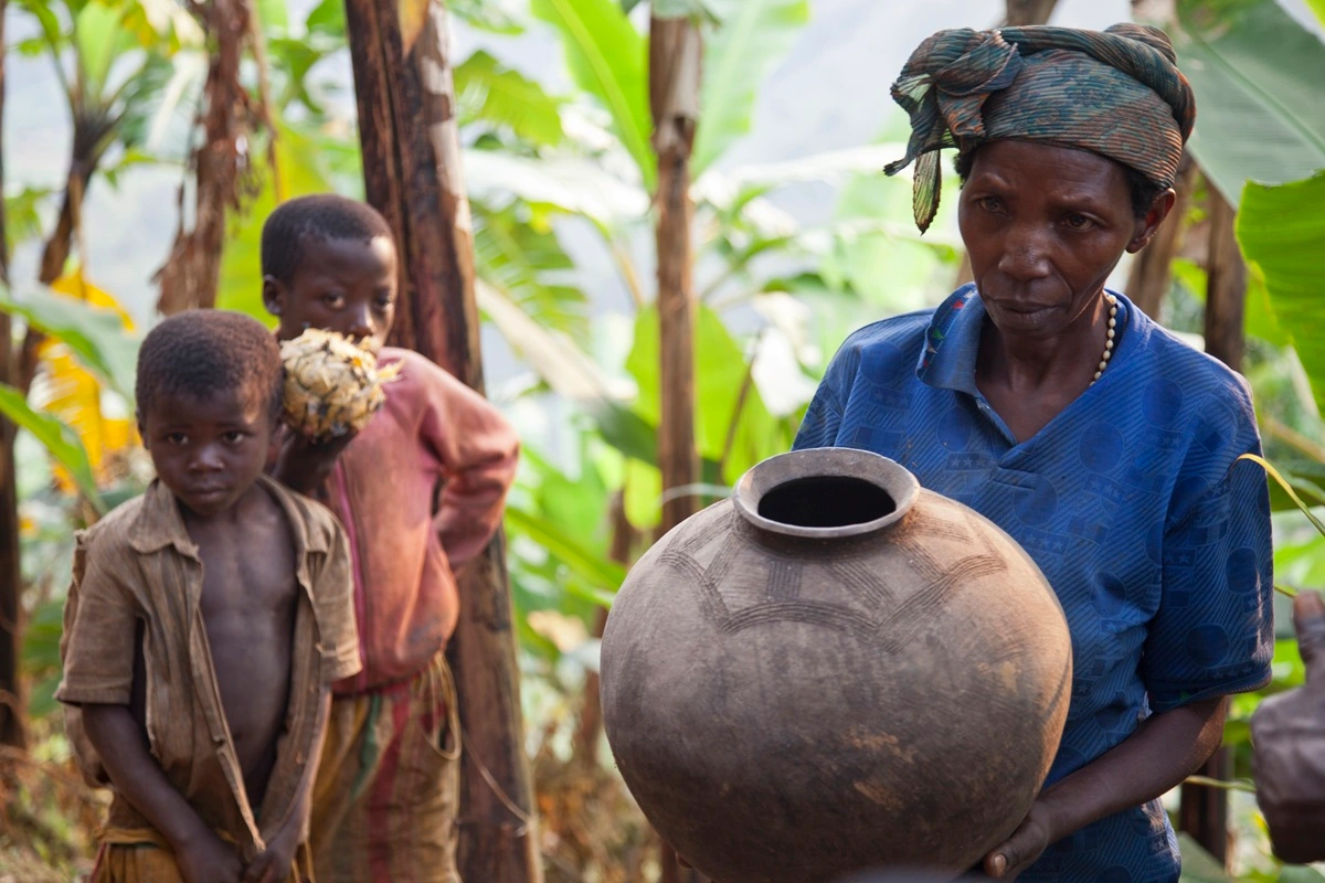 a-woman-carrying-a-large-pot-with-two-children-sta-2025-04-04-23-37-55-utc